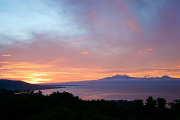 Fototapeta na wymiar colorfull sunset behind mountains of tropical island Siqijor