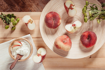 Breakfast with ripe peaches and cottage cheese on  wood board background. Top view. Rustic style.
