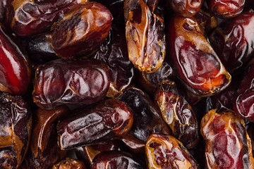 Date fruit closeup background. Heap of dried shiny brown red date fruit. Top view.