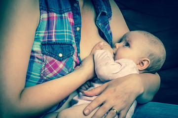 Mother breast feeding newborn baby at home