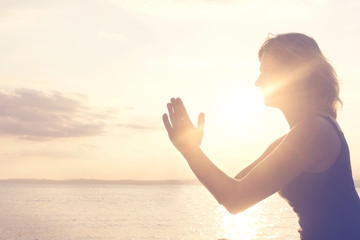 praying hands illuminated by the morning sun