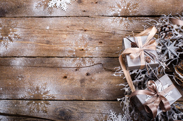 Rustic Christmas wreath with gifts on wooden background. Free space for your text.