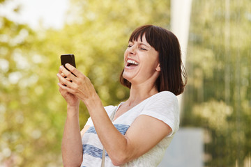 Older woman laughing looking at smart phone
