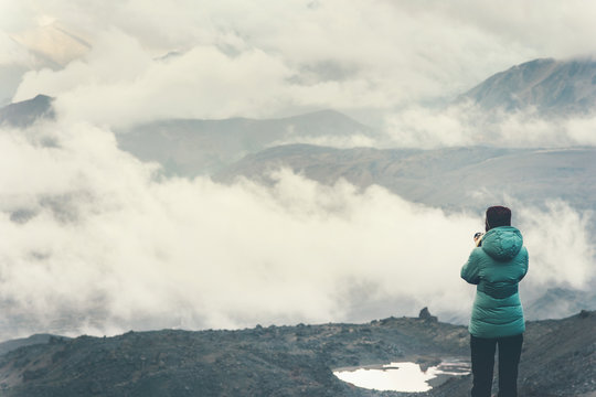 Traveler with photo camera enjoy cloudy foggy mountains landscape Travel Lifestyle concept  adventure vacations outdoor