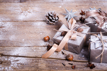 Rustic Christmas wreath with gifts on wooden background. Free space for your text.