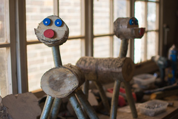 Making wooden reindeer from the logs in the shed; unfinished wooden deers, selective focus