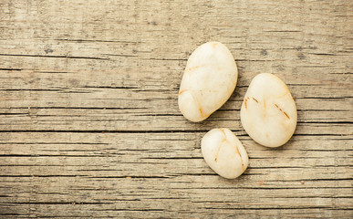 Stones on wooden background, concept of harmony and tranquility. Decoration with stone pebbles as natural design backdrop with copy space.
