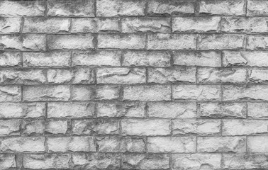 Fototapeta premium Closeup surface brick pattern at old stone brick wall textured background in black and white tone