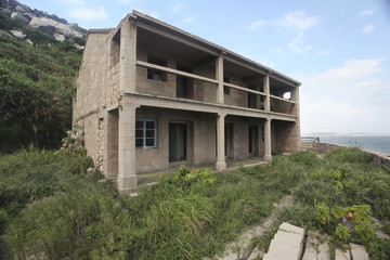 Fototapeta na wymiar an abandoned brick building enterprise house on top of a cliff