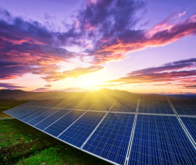 solar panels and wind generators under blue sky on sunset