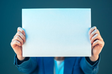 Blank business document paper covering businesswoman's face