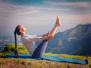 Woman doing Ashtanga Vinyasa Yoga asana Navasana - boat pose