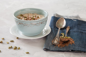 porridge with flax seeds in a bowl on a table, selective focus