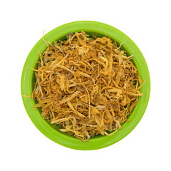 Bowl of shredded calendula flower petals top view isolated on a white background.