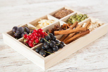 mix of ingredients for a breakfast - oats, a seed, cinnamon and berries on a tray, selective focus