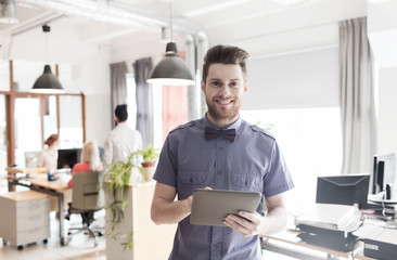 happy creative male office worker with tablet pc