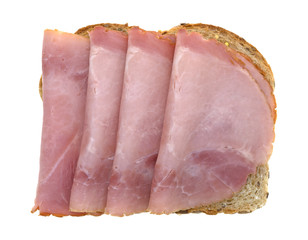 Applewood smoked ham on wheat bread top view isolated on a white background.