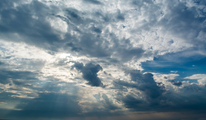 Blue sky with white clouds and curly dark rain clouds. Sky background