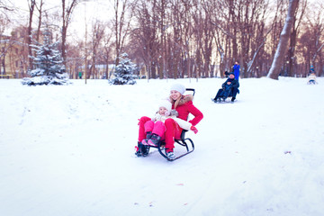 Happy mother and baby playing outdoors in winter