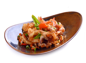 Spicy fried seafood with basil leaves on white background