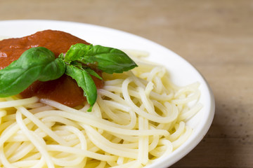 close-up of plate of gluten free spaghetti with tomato sauce and basil