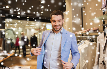 happy young man trying jacket on in clothing store