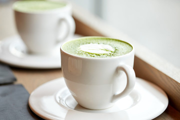 white cup of matcha green tea latte on table