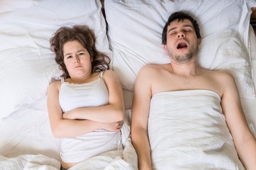 Angry woman cant sleep and listening her husband snoring.