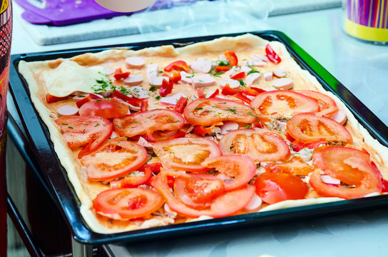 Woman hands grating cheese on the pizza. Young woman preparing the pizza in the kitchen.