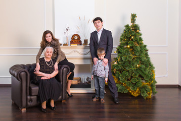 family, holidays, generation, christmas and people concept - smiling family near xmas tree