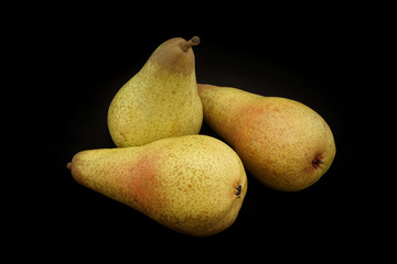 Pears of yellow color on a black background closeup