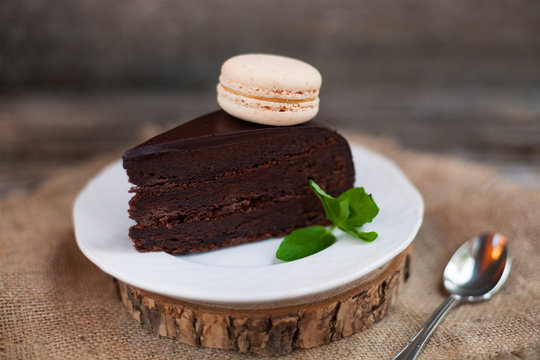 A piece of chocolate cake with fresh mint on the table, close-up
