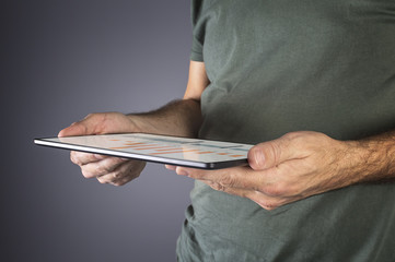 Man hand holding a modern tablet with financial graph