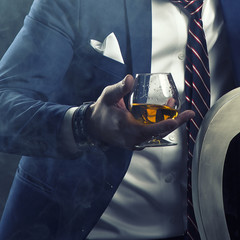Man wearing suit holding cognac glass
