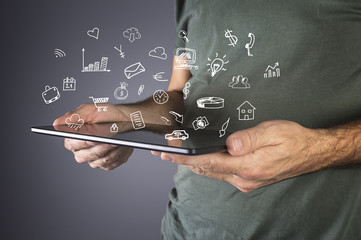 Male hand holding a modern tablet with business icons and symbol