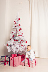 Obraz na płótnie Canvas Cheerful little baby boy playing near the Christmas tree