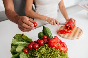 Cropped image of loving couple in the kitchen cooking