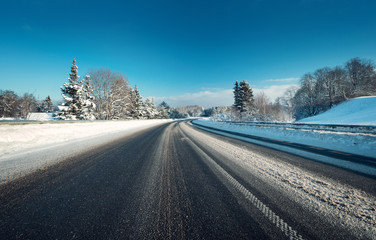 Asphalt road in snowy winter on beautiful frosty sunny day
