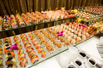 Many pieces of sushi served on glass plate