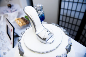 Decorative silver shoe stands on white cake