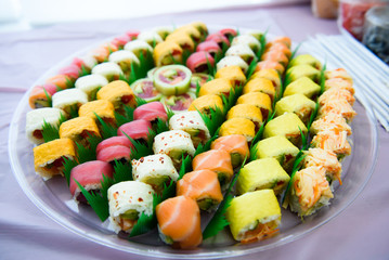 Different colored sushi stand served on glass plate