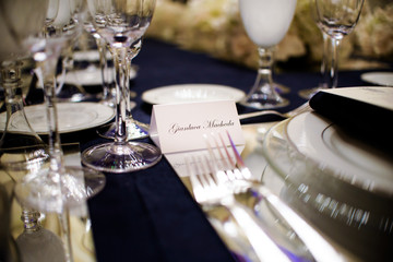 Card with guest's name lies before sparkling flatware