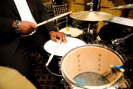 Man with thick bracelets on wirsts plays on drums
