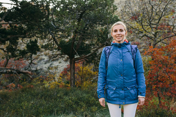 young woman traveler standing on the background of mountain and forest