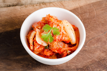Kimchi cabbage (Korean food) in a bowl on wooden background