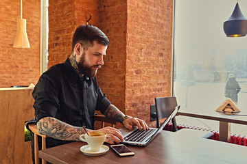 A man relaxing at the table after work with a laptop.