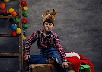 A boy posing on Christmas decorated background.