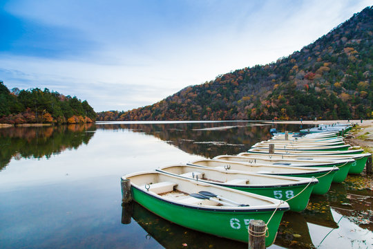 Fishing boat park on lake in evening autumn mountain