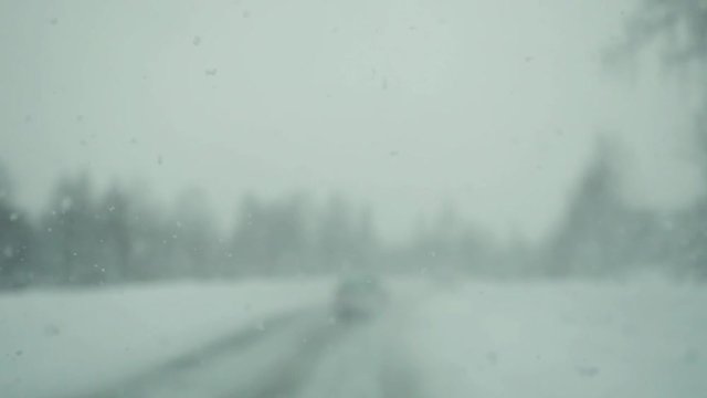 Car driving on snow road during deep snowfall in slowmotion. 1920x1080