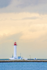 The lighthouse on the background of the cloudy sky